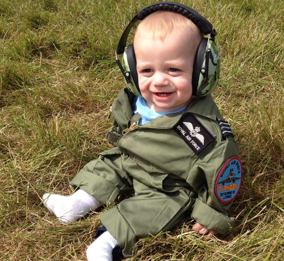 A baby in an RAF flying suit