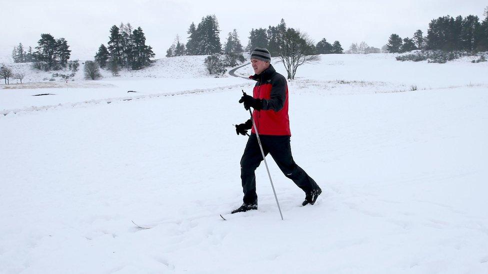 A man trekking through the snow in Gleneagles