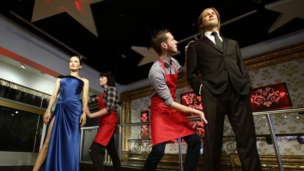 Workers at Madame Tussauds move the Brad and Angelina waxworks