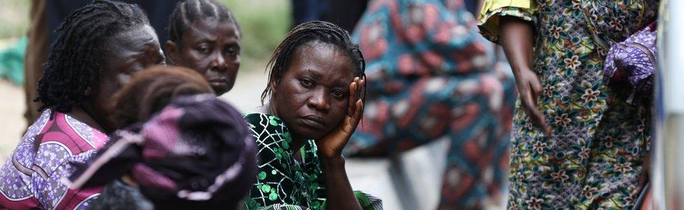 Relatives wait outside as rescue workers continue to conduct search and rescue effort at the site of a collapsed building in Ikoyi, Lagos, Nigeria