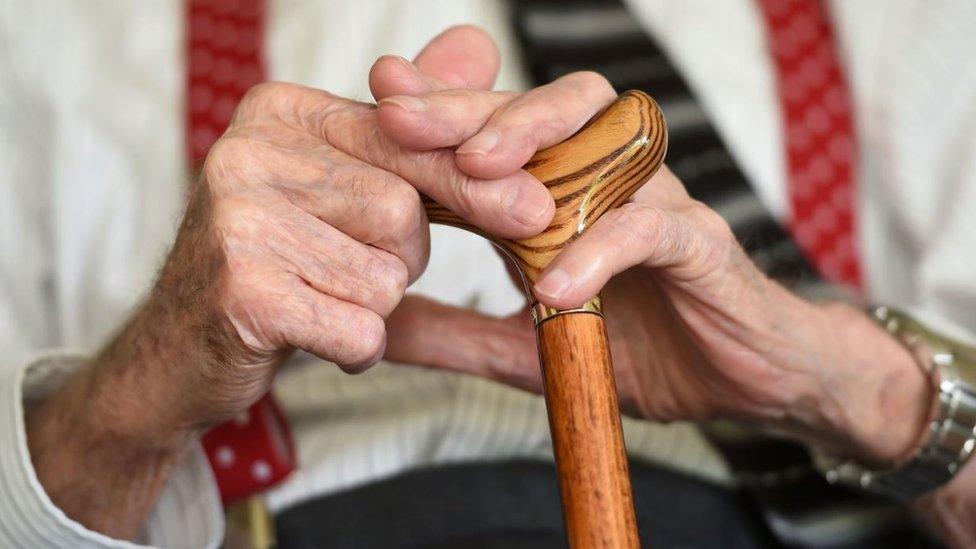 Elderly man holding a walking stick