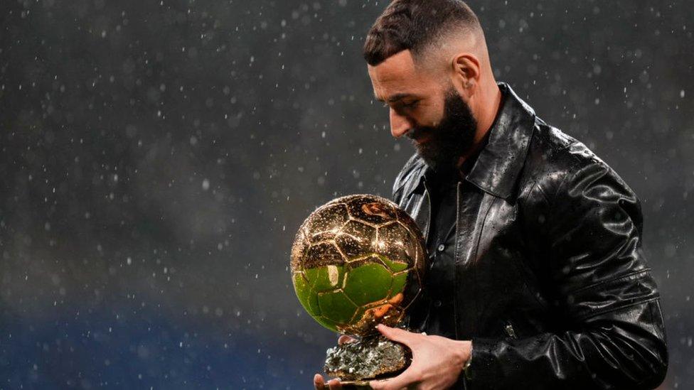 Karim Benzema shows his recently won Ballon d'Or trophy.