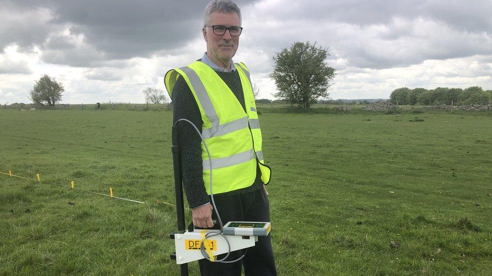 Phil Cox standing in a field with a hi-vis jacket on