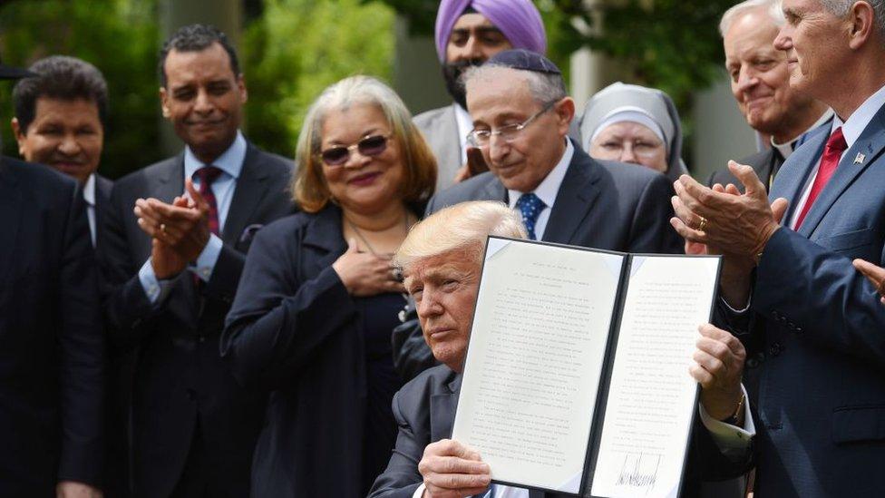 US President Donald Trump signs an executive order in the Rose Garden at the White House.