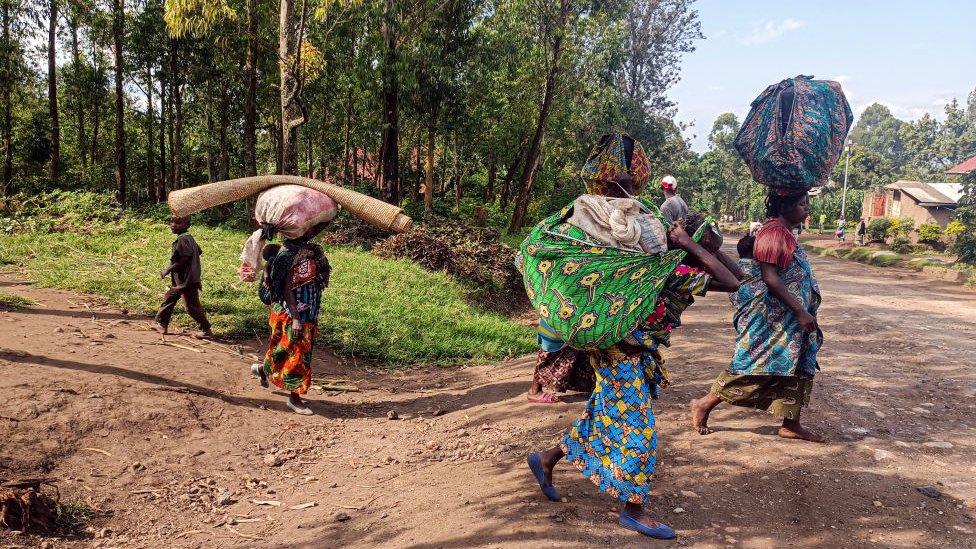 People carrying their belongings