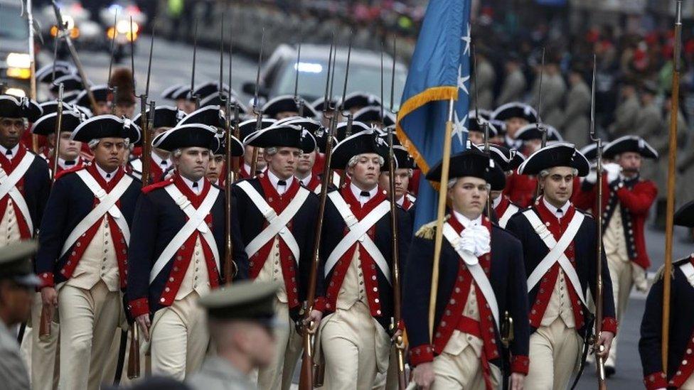 Participants march in period costumes on Pennsylvania Avenue