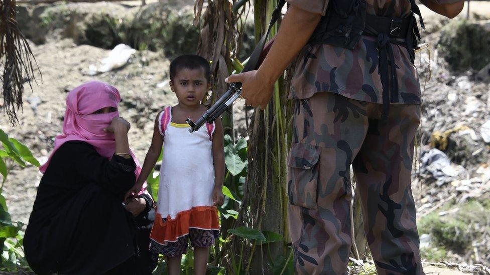 A Bangladeshi border guard stands guard at the Jalpatoli refugee camp for Rohingya Muslims near Gumdhum village in Ukhia, 16 September