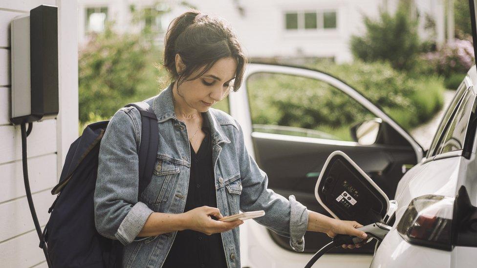 Woman charging electric car