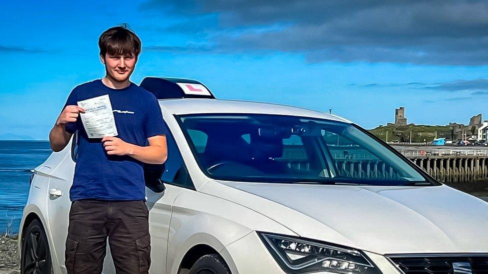 Connor Davies holding his driver's certificate.