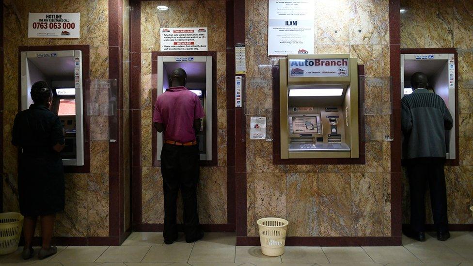 Kenyans withdrawing cash from an ATM