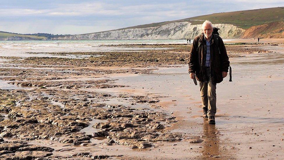 dr lockwood walking along a beach on the isle of wight