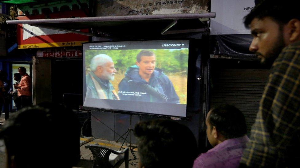 People watch "Man vs Wild" featuring Narendra Modi at a giant screen in Bhopal, India