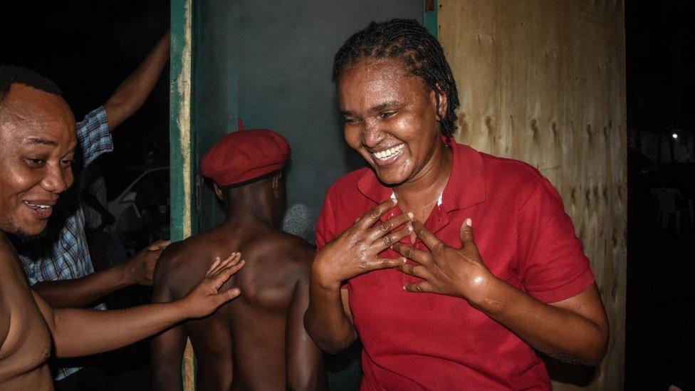 A woman reacts as a customer enters a steam inhalation booth in Dar es Salaam, Tanzania, on May 22, 2020