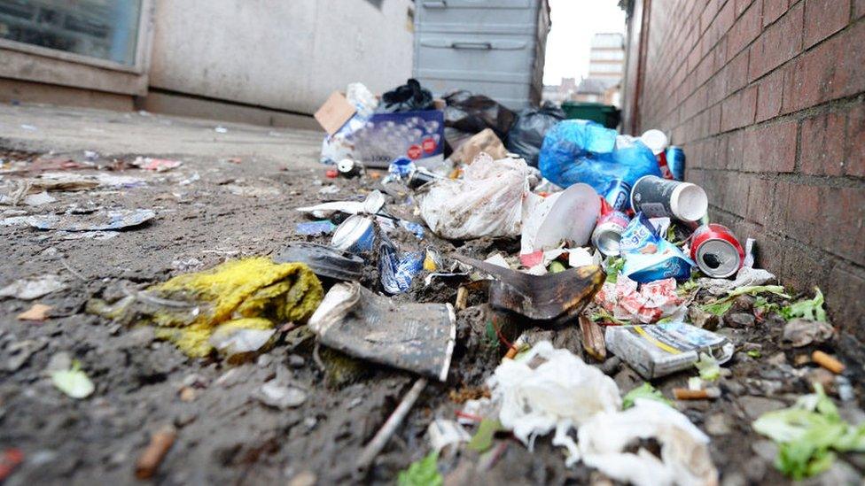 Litter piled up next to a bin