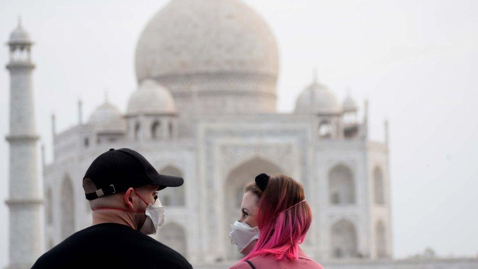 Tourists wear face masks as a preventive measure against the spread of the COVID-19 coronavirus outbreak, near Taj Mahal in Agra on March 5, 2020