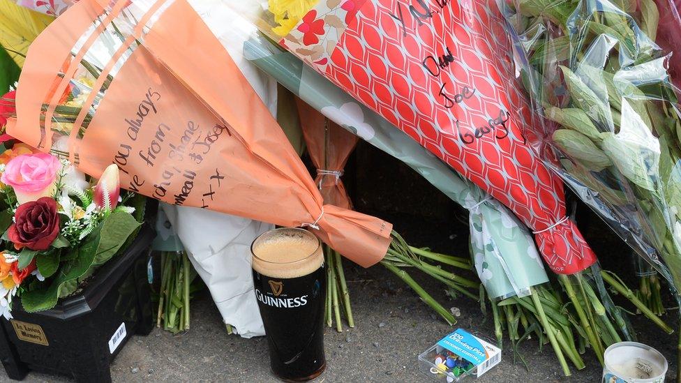 pint of guinness and flowers left as tribute