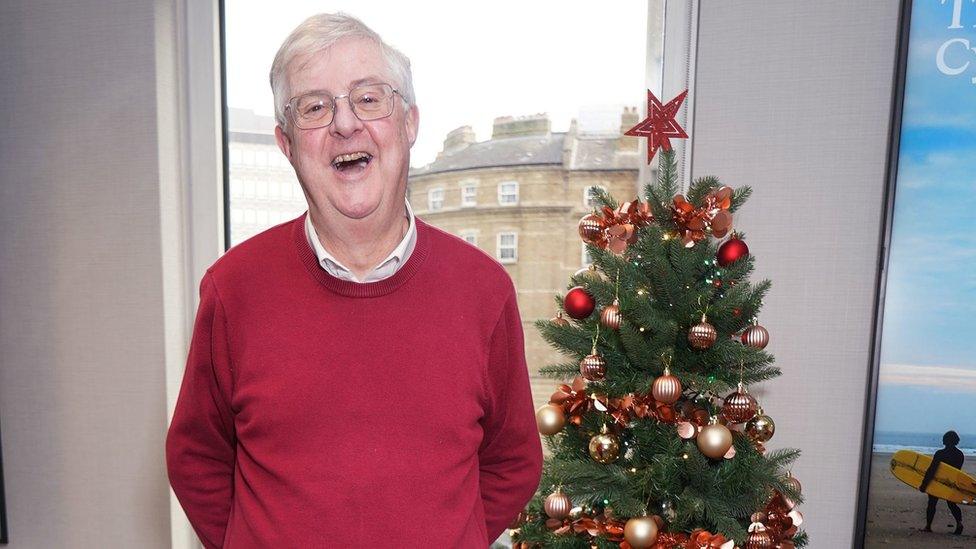 Mark Drakeford next to a Christmas tree