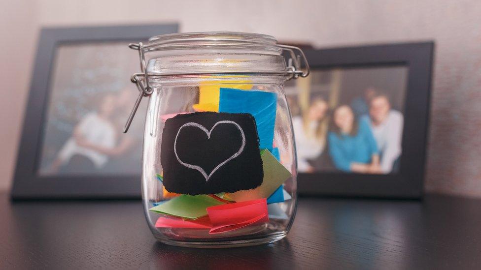 Memory jar in front of photo frames