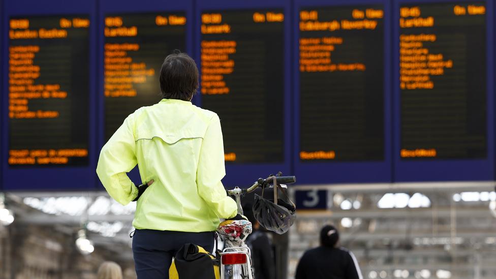 Person looks at train times at a station