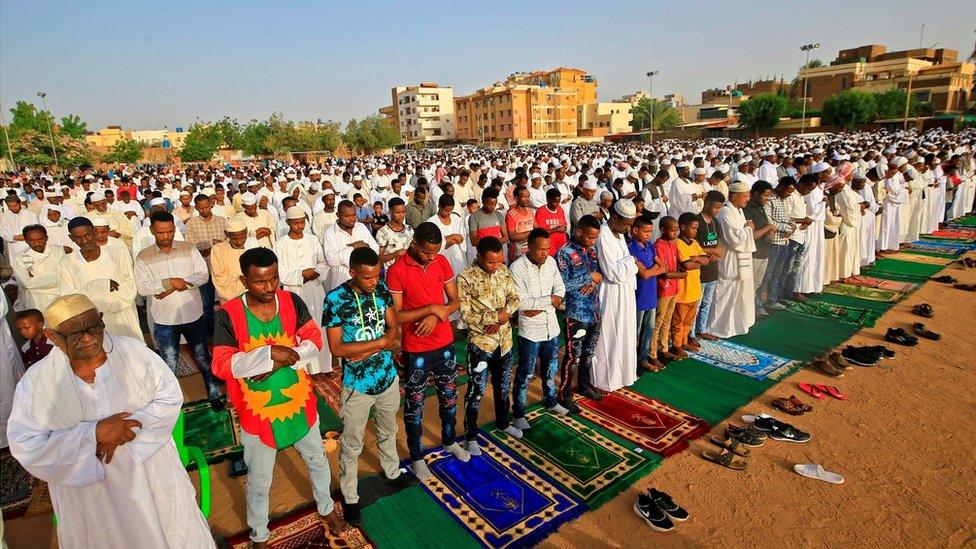 Muslim worshippers gather for the prayers of Eid al-Fitr, the Muslim holiday which starts at the conclusion of the holy fasting month of Ramadan, in the district of Jureif Gharb of Sudan"s capital Khartoum early on May 24, 2020, despite government regulations banning congregations due to the COVID-19 coronavirus pandemic.