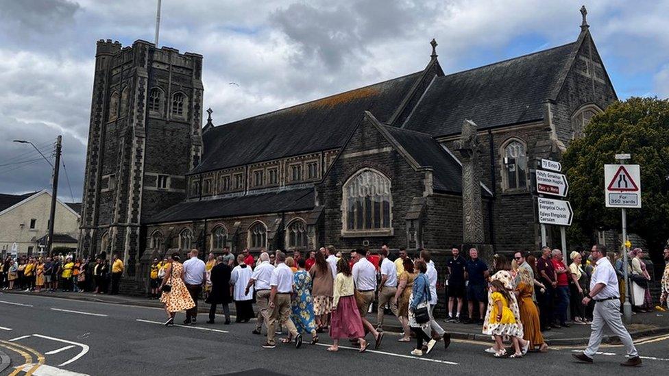 Funeral attendees enter church