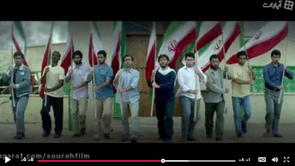 Iranian men line up with flags