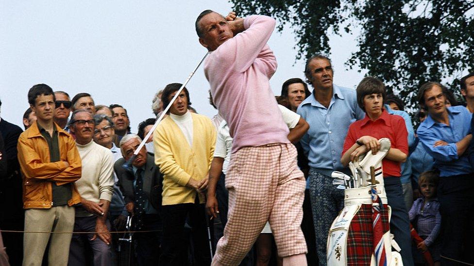 Max Faulkner - dressed in a pink sweater - swinging his golf club