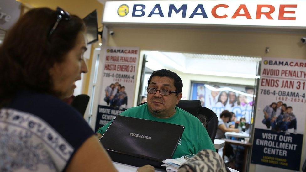 An insurance agent helps a Miami, Florida, woman pick out her health care plan