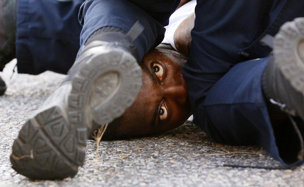 A man protesting the shooting death of Alton Sterling is detained by law enforcement near the headquarters of the Baton Rouge Police Department in Baton Rouge, Louisiana, U.S. July 9, 2016