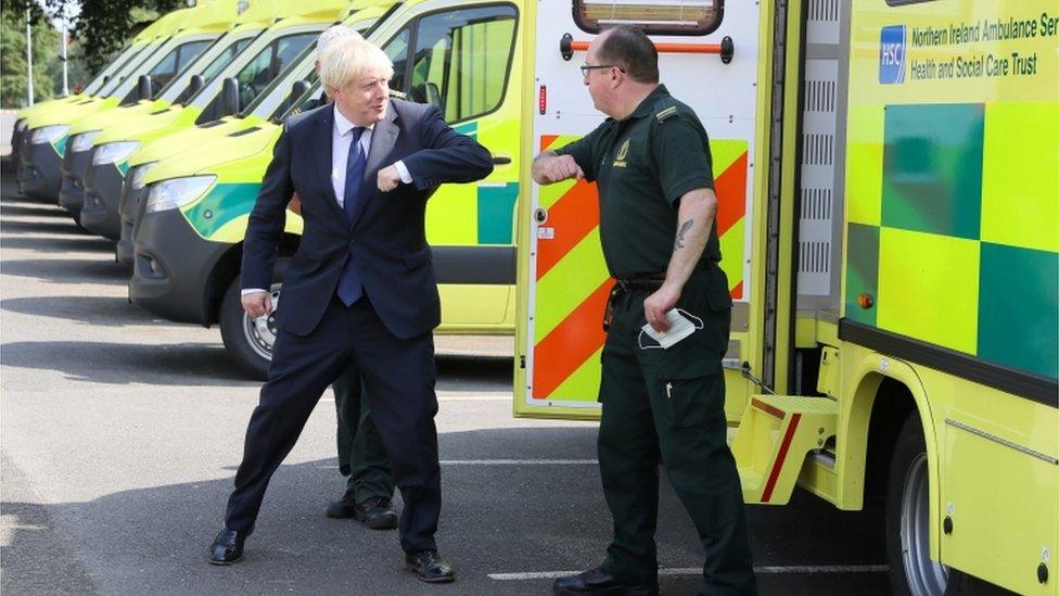 Britain's Prime Minister Boris Johnson elbow bumps a paramedic at the Northern Ireland Ambulance Service HQ during his visit to Belfast