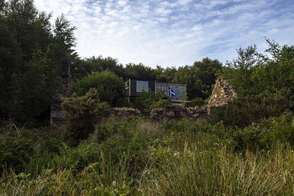 Ruins of a former croft in front of a current residence