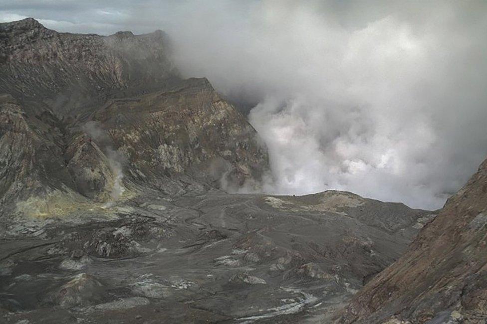 A video screenshot of the volcano spewing steam and ash