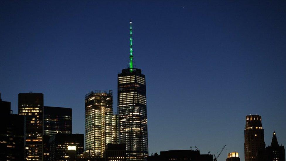 One World Trade Center glowing green against New York skyline