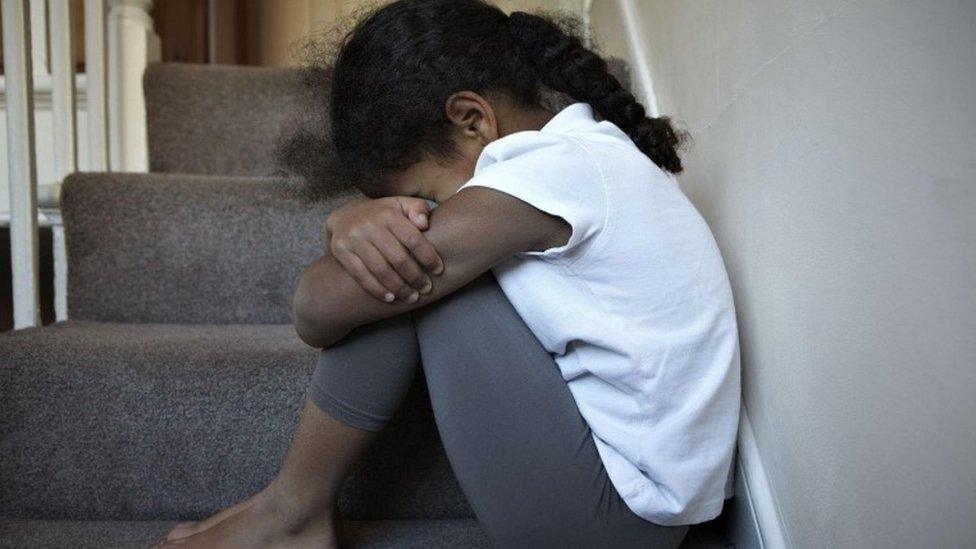 Child sitting on stairs (posed by model)