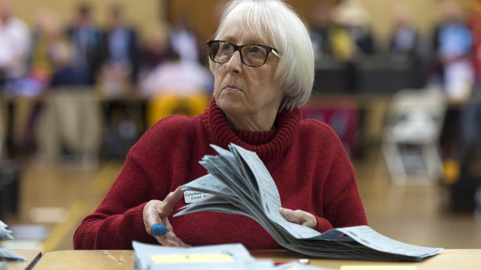 A woman counts ballot papers at Llanishen Leisure Centre on May 4, 2017 in Cardiff, Wales.