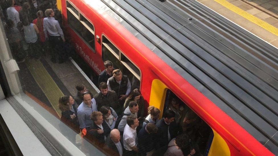 Commuters trying to get on an overcrowded train at Putney