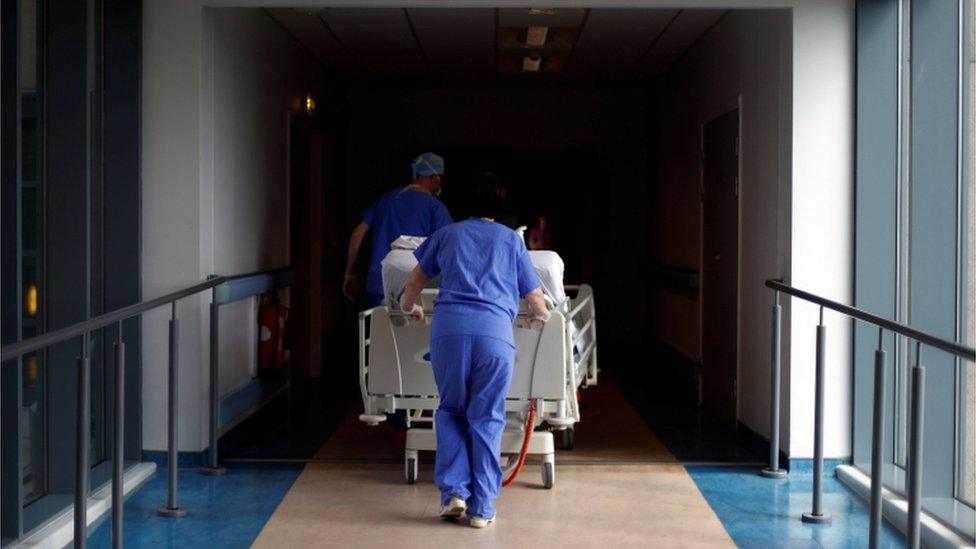 A patient being wheeled through a hospital corridor