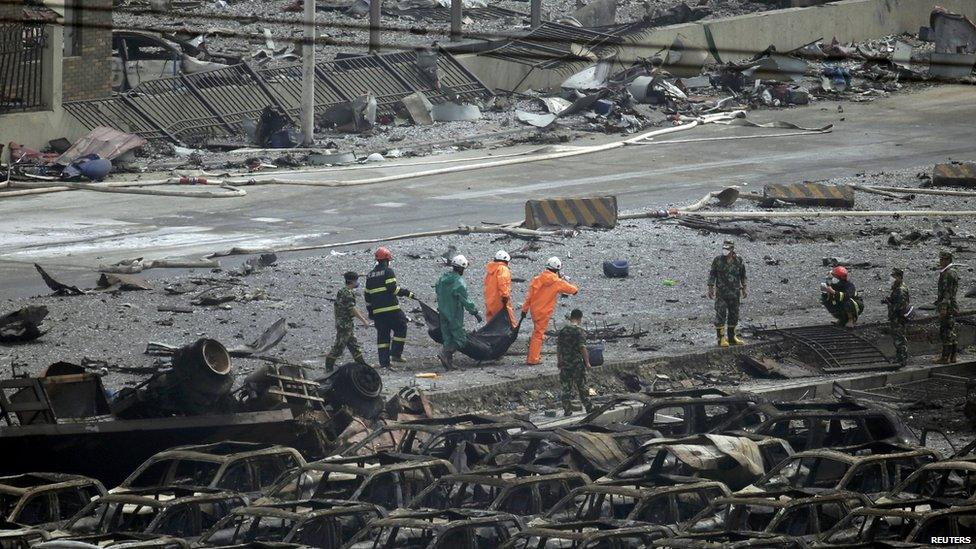 Rescue teams carry body of victim away from scene of blast. 14 Aug 2015