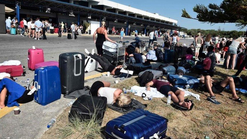 Tourists gather outside terminal buildings at an airport on the island of Kos on July 21, 2017, after flights were cancelled following a 6.5 magnitude earthquake