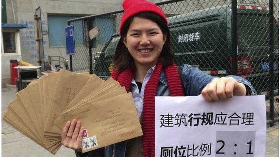 Women activist Li Tingting, 25, poses with letters and a paper which read "Construction regulations should be reasonable, bathroom proportion 2:1 (women/men)" in this undated file handout picture taken in an unknown location in China, provided by a women"s rights group on 8 April 2015