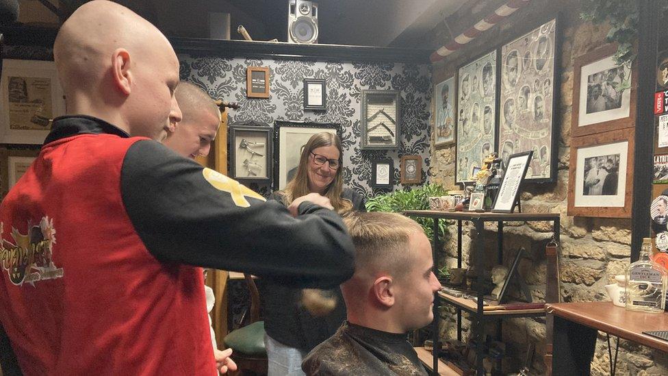 Owen watching one of his team-mates having his hair shaved off