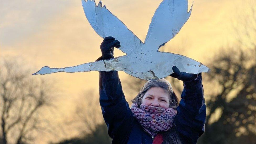 Poppy Lakner holding a metal swan