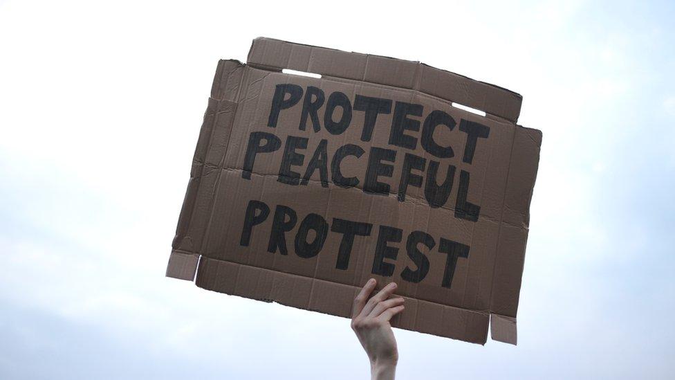 A demonstrator holds a placard during a protest against a new proposed policing bill in Bristol, Britain, March 30, 2021.