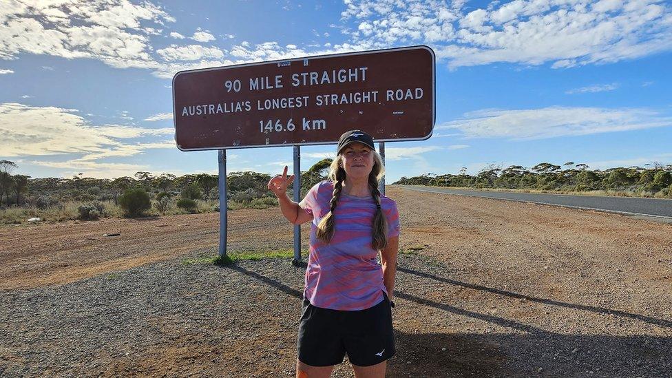 Nikki Love beside sign for Australia#s ;l