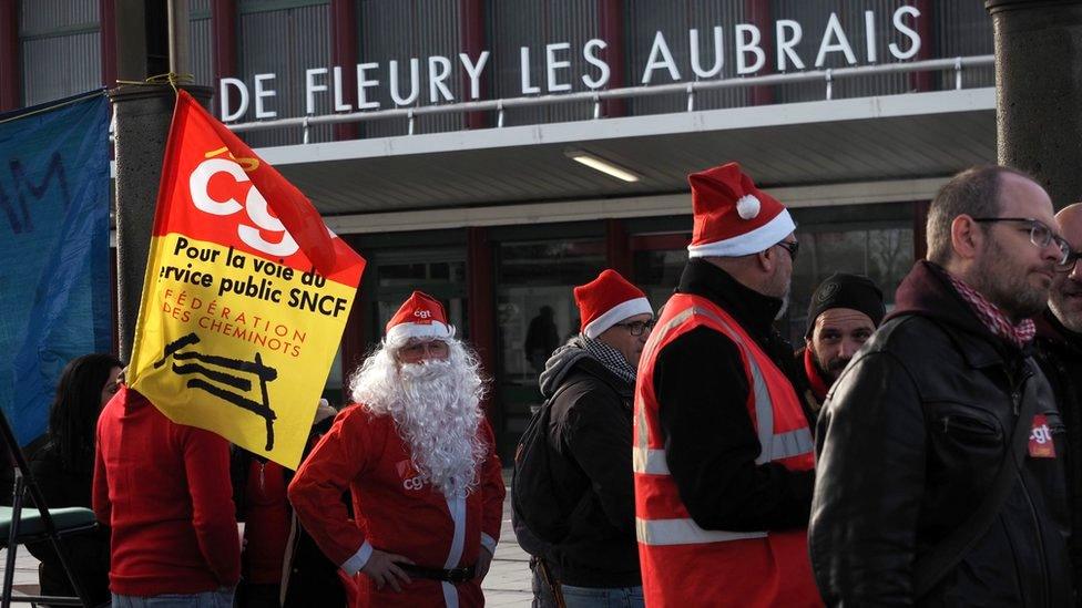 SNCF railway workers serve Christmas dinners in front of the Les Aubrais station near Orleans, central France, 23 December 2019