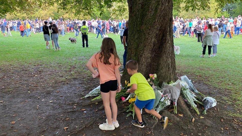 Alina and her brother Richard leaving a floral tribute