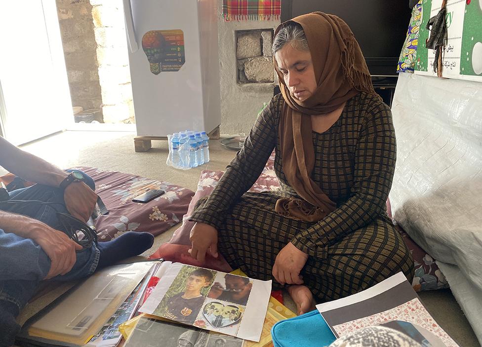 Bahar looks at pictures of her missing husband and son, now presumed murdered