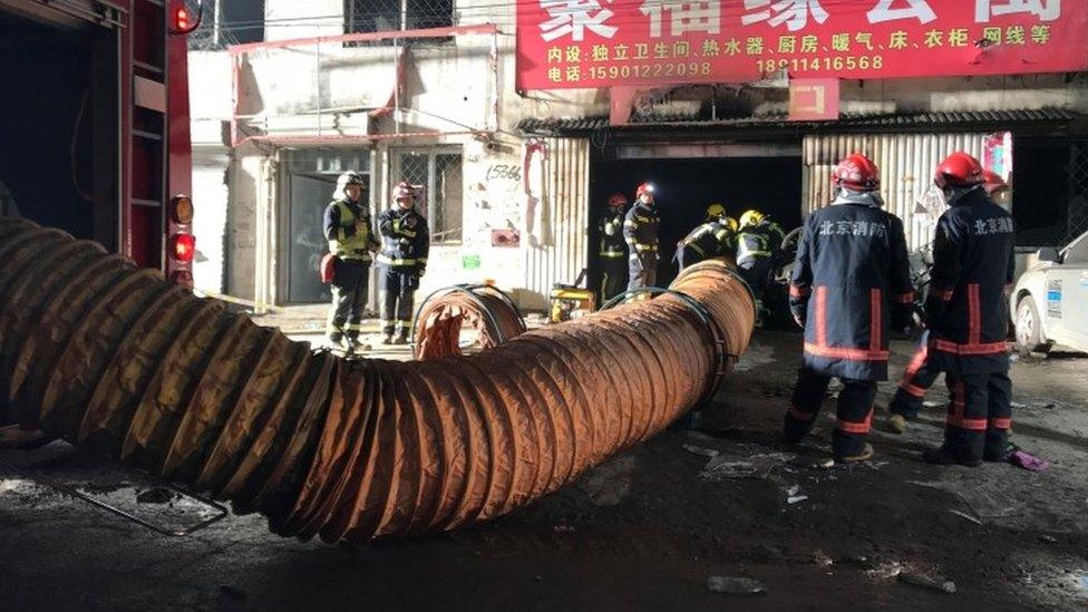 Firefighters work at the site of a house fire, in Daxing district, Beijing, China (19 November 2017)