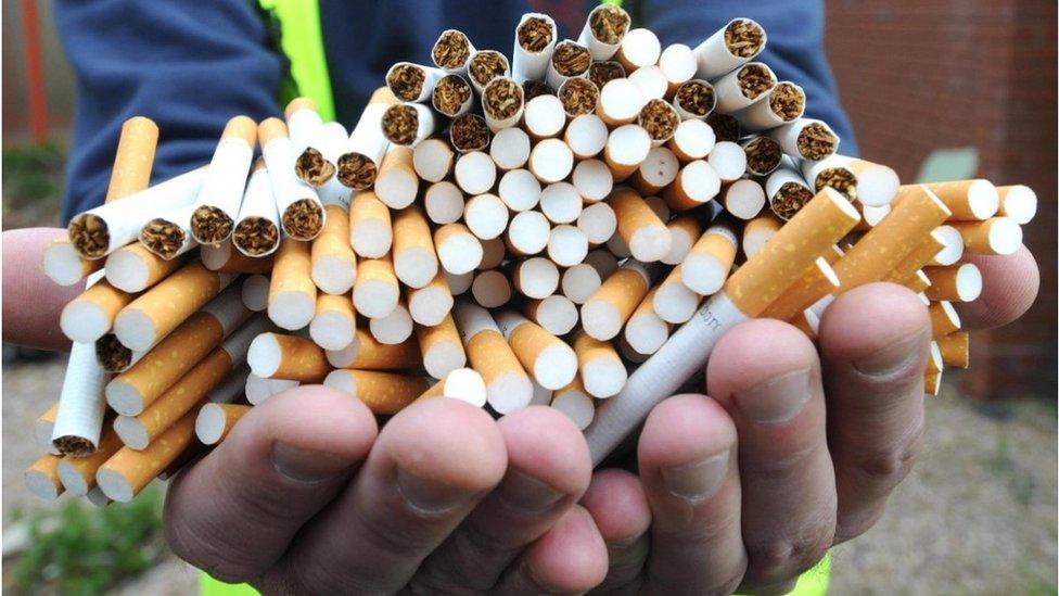 Hands holding a haul of cigarettes