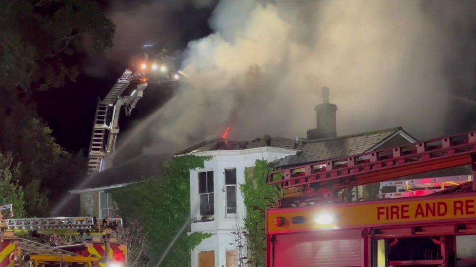 Crane with firefighters tackling fire